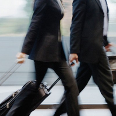 2 people walking with suit cases